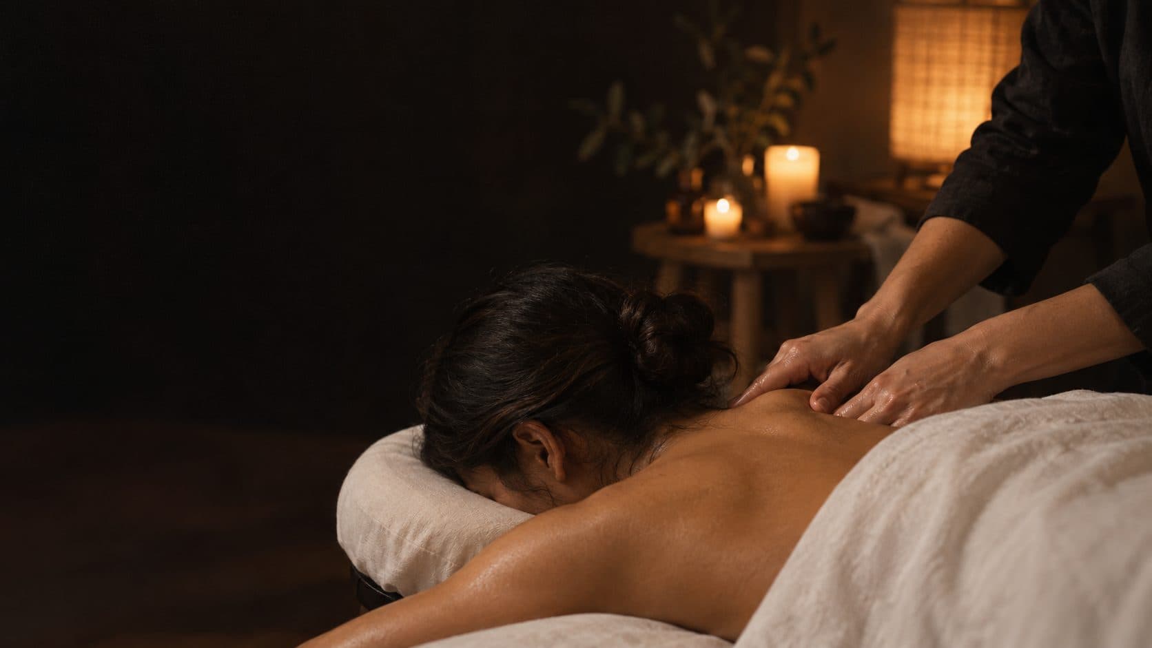 Therapist giving a massage by candlelight in a client's home